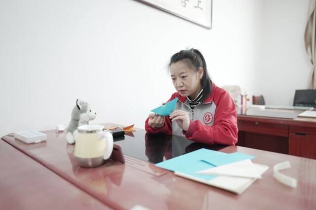 王雅妮在内蒙古呼和浩特市特殊教育学校的办公室里给学生们上网课（2022年4月28日摄）。新华社记者达日罕摄