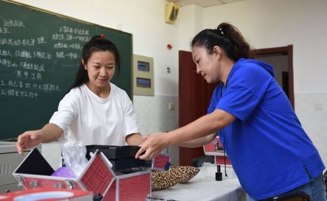 在内蒙古呼和浩特市特殊教育学校，王雅妮（中）给两位聋哑学生补课（2022年8月8日摄）。新华社记者连振摄