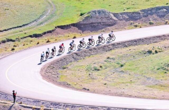 参赛选手在环赛里木湖公路自行车赛骑行。新华社发
