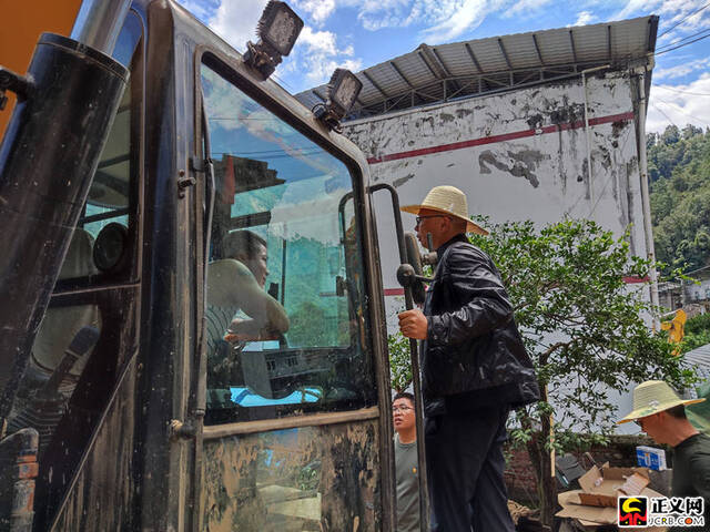 石棉县检察院党组书记、检察长羊辉正在和挖掘机师傅商量拆除顺序、路线。