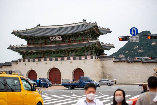 7月12日，车辆和行人在韩国首尔光化门前经过。新华社记者王益亮摄
