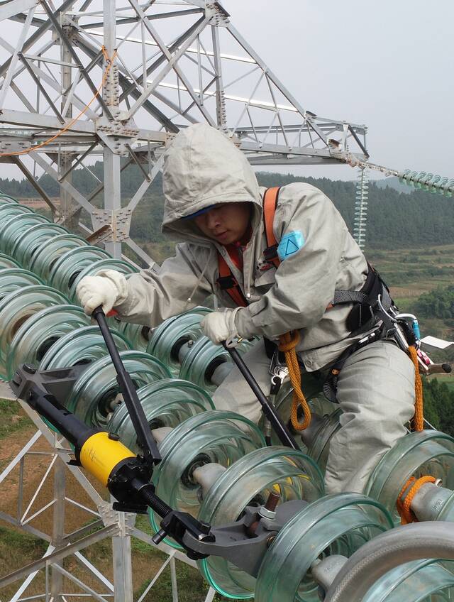 邱中华在500千伏谭邡线运用自主研制的工器具开展带电作业。受访者供图