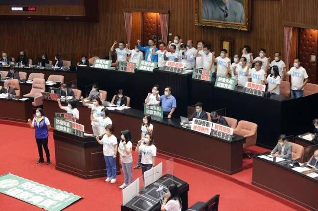 国民党“立委”占领会场主席台与发言台，抵制苏贞昌施政报告，要求民进党为防疫失能道歉。图片来源：台湾联合报许正宏摄