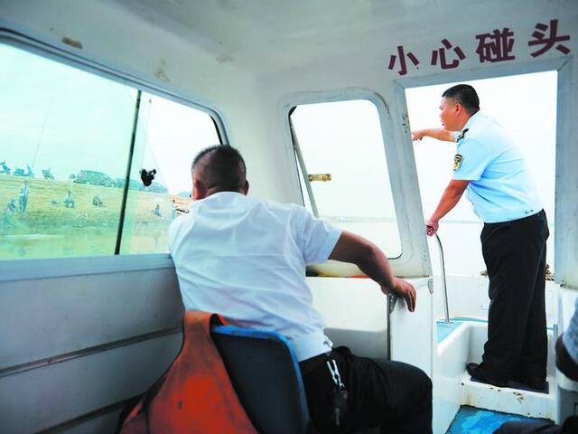 9月7日，江西都昌县，为了保障水源安全，渔政干部驾船来到观湖水厂附近水域，劝说钓鱼爱好者离开。新京报记者郭延冰摄