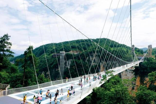 7月21日，湖南张家界大峡谷风景区高空峡谷玻璃桥上的游客。摄影/本刊记者韩辉