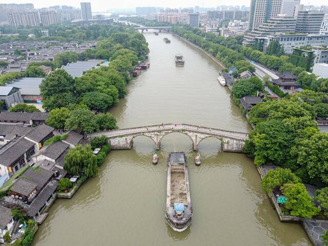 5月27日，一艘货船驶过京杭大运河南端标志建筑杭州拱宸桥。（无人机照片）新华社记者江汉摄