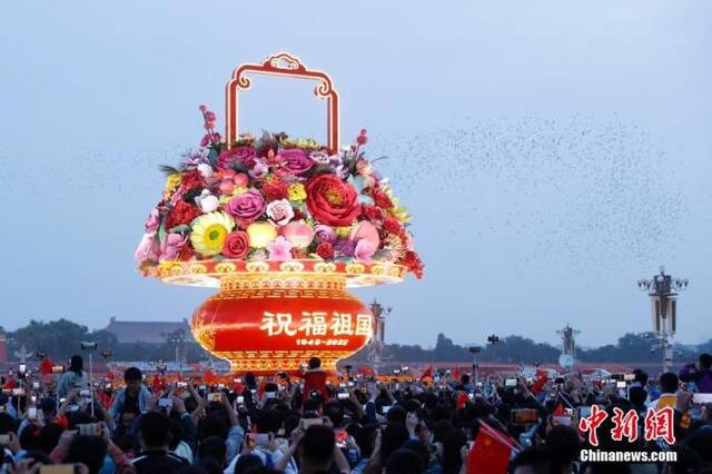 图为市民游客拍摄天安门广场中的国庆主题花坛。中新社记者韩海丹摄