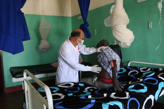9月23日，在卢旺达东方省基本戈医院，中国第22批援卢旺达医疗队队员李俊升为患者做检查。新华社发（黄万晴摄）