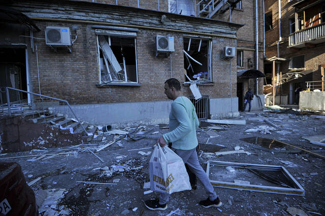 10月10日，乌克兰基辅，一名男子走在一座因俄罗斯军队导弹袭击而受损的建筑旁边。图源：视觉中国VCG31N1243880265