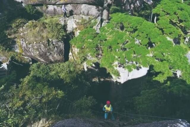 李培生在黄山风景区的悬崖峭壁间清捡垃圾（2022年8月15日摄）。