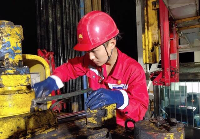 10月17日，黑龙江大庆油田1205钻井队青年员工葛依凡在作业中。新华社发（段永坚摄）