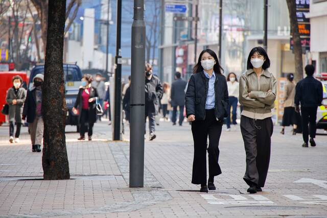 当地时间2022年3月16日，韩国首尔，首尔街头的青年人。澎湃影像图