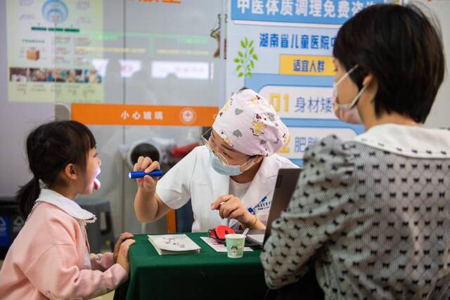 10月21日，在湖南省儿童医院，中医医师（中）正在为儿童诊治。新华社记者陈思汗摄