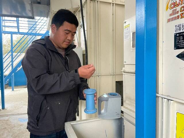 安徽省天长市种粮大户平东林在烘干厂房检测水稻水分。（新华社发）