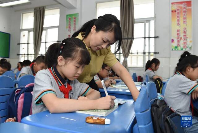 ▲资料图。合肥市某小学，老师在语文课上指导学生。图/新华社