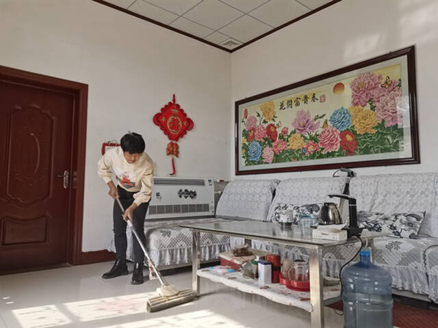 10月24日，邱瑞东的妻子邱志芬在打扫客厅。新华社记者杜一方摄