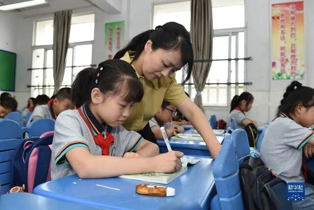 ▲资料图。合肥市某小学，老师在语文课上指导学生。图/新华社