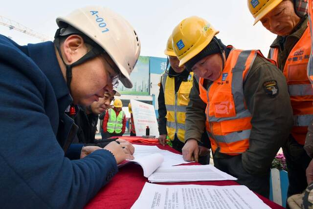 山东济南一处工地，项目负责人与农民工一同核对工资收入。新华社记者朱峥摄