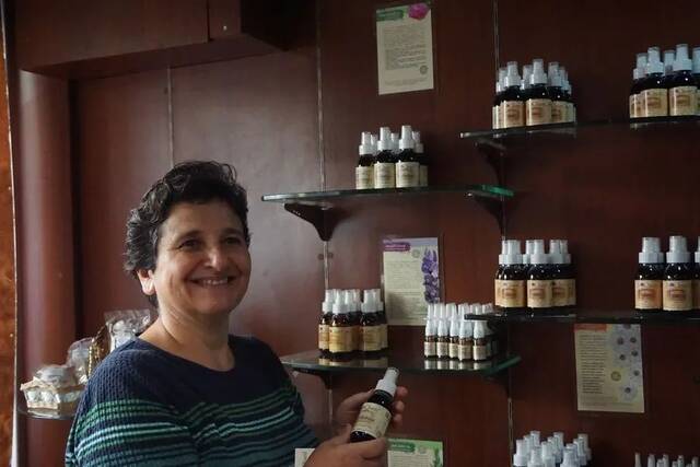 图片10月23日，在叙利亚首都大马士革，鲁拉·阿迪卜展示自家企业生产的玫瑰纯露。新华社记者汪健摄