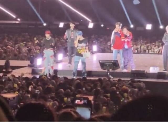 韩国男团NCT 127在雅加达演唱会现场向台下观众分发小礼品。图自韩媒