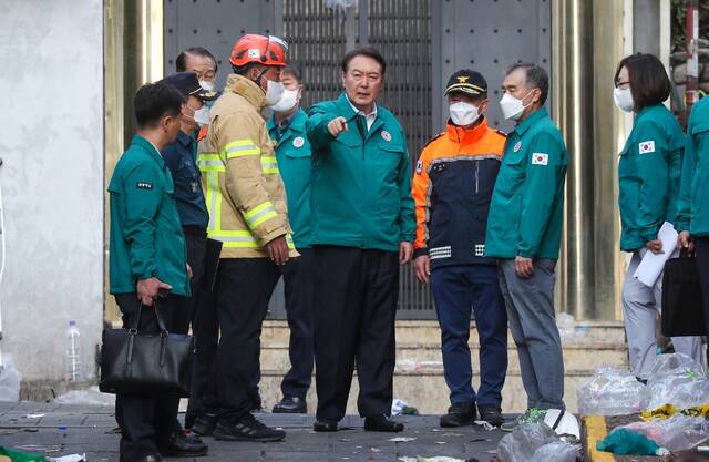 10月30日，韩国总统尹锡悦（右四）在首尔市龙山区梨泰院洞踩踏事故现场了解情况。新华社发（李相浩摄）