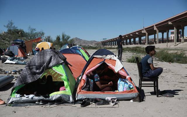 当地时间2022年10月26日，墨西哥华雷斯，等待穿越美墨边境的无证移民在河岸边的美国边境巡逻行动哨所前滞留。