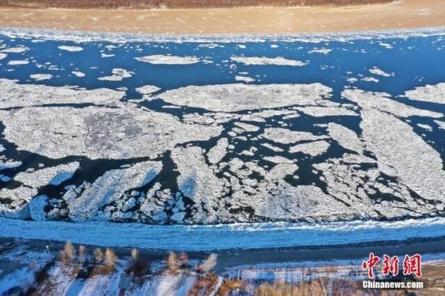 立冬节气，受冷空气影响，中俄界江黑龙江呼玛段当天进入冬季流冰期，连绵不断的冰排顺江而下，形成了壮观的“跑冰排”美景。（无人机照片）中新社发王婷摄