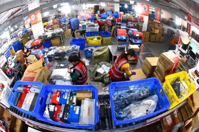2022年11月11日，江苏连云港，海州区天马电商产业园内，工人正在查找、封装打包、发送快递包裹。视觉中国图