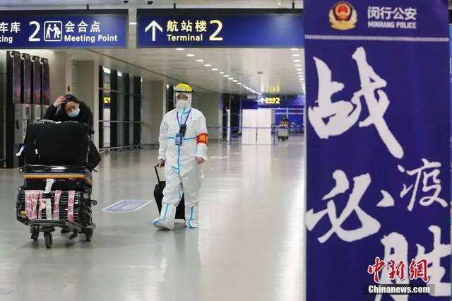 上海浦东机场，工作人员帮助旅客搬运行李。图片来源见水印