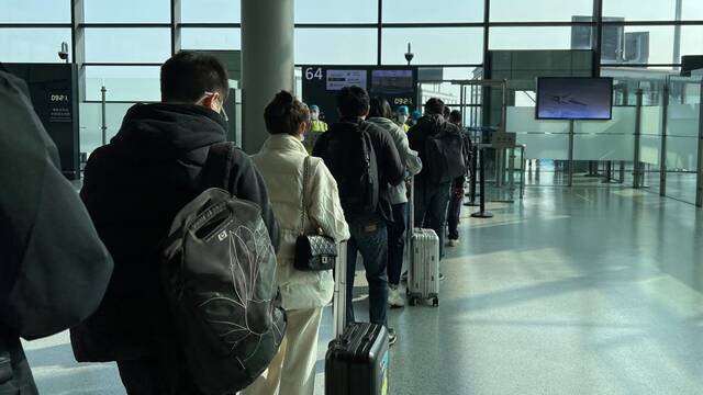 2022年11月16日，上海，旅客在大厅排队检票。视觉中国图