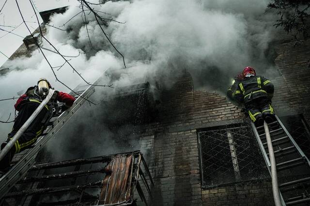 当地时间2022年11月15日，乌克兰基辅，在Pecherskyi区的两栋居民楼被击中后，消防员正在努力扑灭大火。人民视觉图