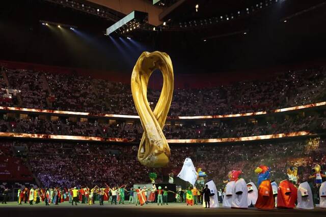 ▲2022年11月20日，2022年卡塔尔世界杯会徽出现在开幕式现场。当日，2022年卡塔尔世界杯开幕式在海湾球场举行。图/新华社