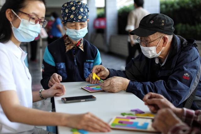 9月21日，北京，三里河二区社区养老服务驿站内，老人们正在玩拼图游戏。新京报记者王嘉宁摄