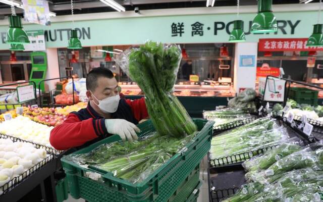 ▲2022年11月23日，京客隆劲松店工作人员正在给蔬菜区上货。新京报记者王飞摄