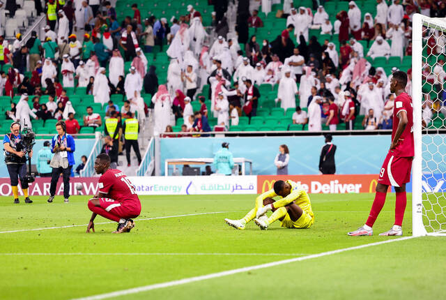 11月25日，卡塔尔队球员穆罕默德·蒙塔里、米沙勒·巴希姆和莫耶茨·阿里（右至左）在比赛后。新华社记者丁旭摄