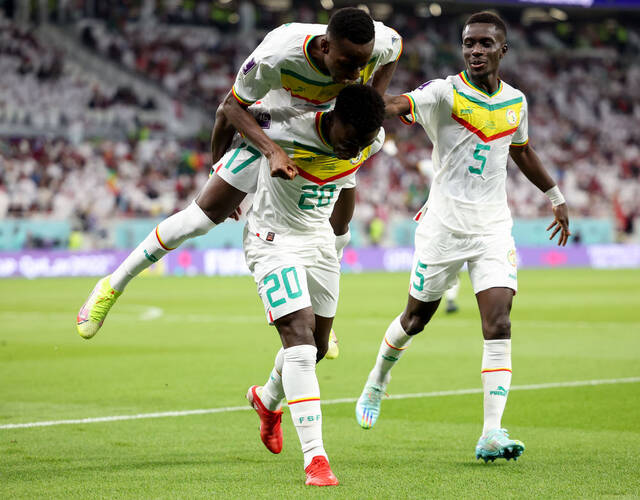  11月25日，塞内加尔队球员班巴·迪昂（前，20号）打入球队第三粒进球后与队友帕普·萨尔、伊德里萨·格耶（右）庆祝。新华社记者韩岩摄