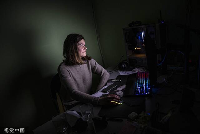 当地时间2022年11月21日，乌克兰基辅，一名妇女在接受采访时，使用一台由发电机供电的电脑。人民视觉资料图