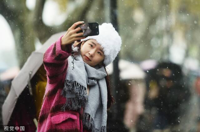 2022年12月1日，杭州迎来降雪天气，游客雪中游览西湖断桥。视觉中国图