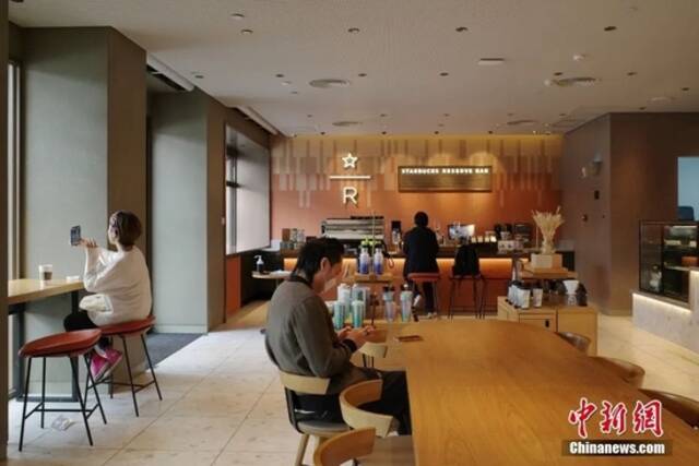 12月1日，广州市海珠区，市民在客村地铁站附近喝咖啡。中新社记者陈楚红摄