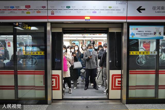2022年12月5日，郑州，周一早高峰地铁人流量增加，市民戴口罩搭乘地铁有序出行。人民视觉图