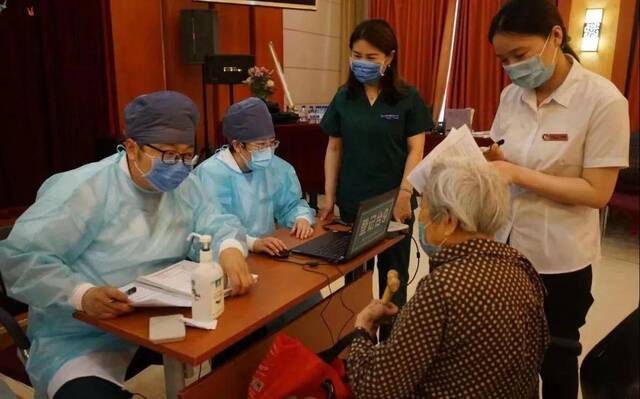 ▲在北京某养老院，医护人员为老人做新冠疫苗接种前的信息登记。新京报资料图