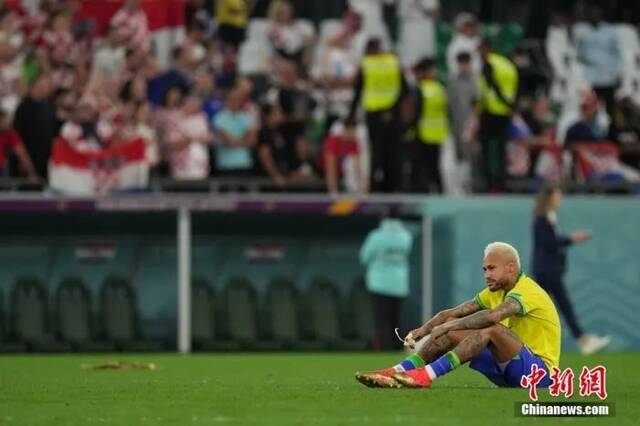 当地时间12月9日，卡塔尔世界杯1/4决赛举行，图为内马尔失落地坐在球场中。中新社记者崔楠摄