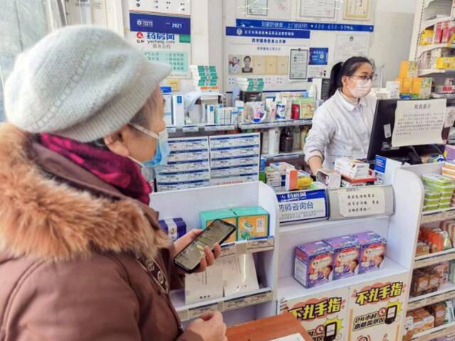 ▲12月8日，北京海淀黄庄一位老年人拿着清单购买相关药品。新京报记者浦峰摄