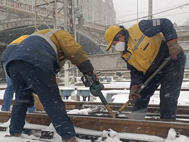 中国铁路沈阳局集团有限公司大连工务段职工及时清除道岔转辙部分等关键部位积雪，确保线路安全畅通。（受访者供图）