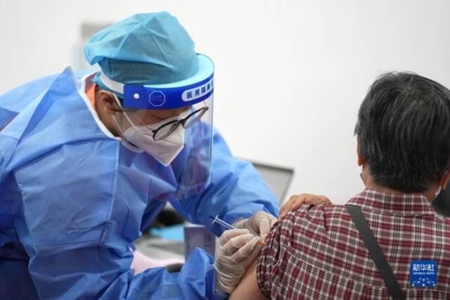 在北京市朝阳区奥运村街道一处新冠疫苗接种点，医护人员为一市民接种新冠疫苗加强针（2022年7月13日摄）。新华社记者鞠焕宗摄