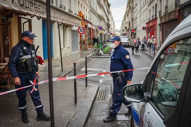当地时间2022年12月23日，法国巴黎，警察设置警戒线进行调查。法国警察和医护人员抵达巴黎昂吉安街的枪击现场。图/视觉中国