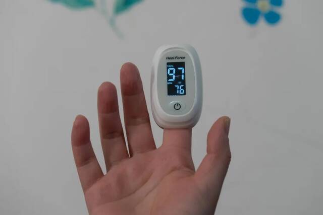 2022年12月18日，上海，市民在家中通过指夹式血氧仪测量血氧饱和度和心跳。（图