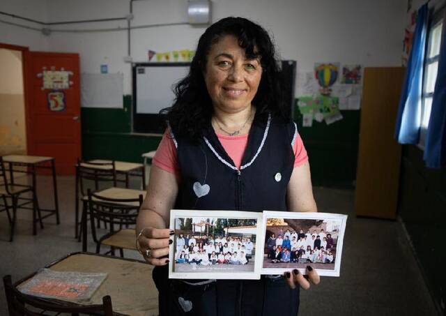 12月22日，梅西的小学老师安德烈娅·索萨向记者展示梅西小学时所在班级的集体照。新华社发（马丁·萨巴拉摄）