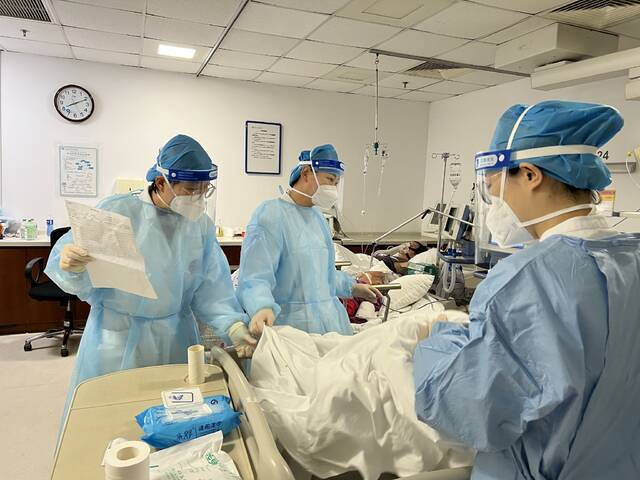 12月28日，北京大学国际医院急诊科内，医护人员正在病房对患者进行问诊。北京大学国际医院供图