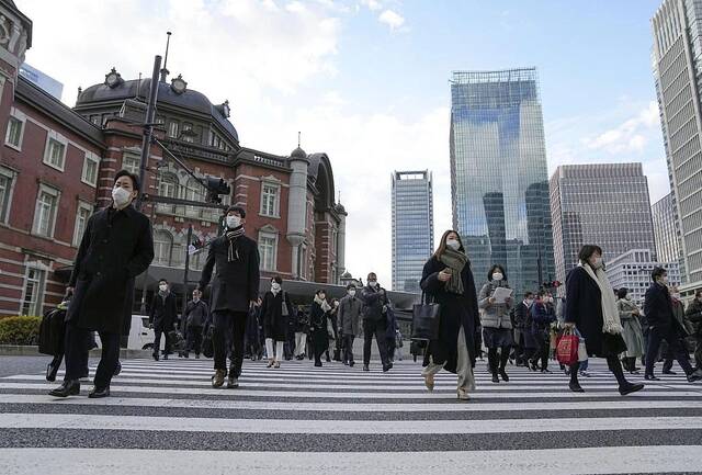 当地时间2022年12月28日，日本东京站前，戴着口罩上班的上班族在2022年的最后一个工作日上班。图/视觉中国